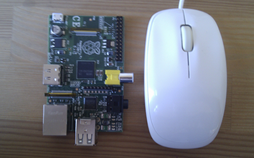 Raspberry Pi board next to a computer mouse - the two are similar sizes